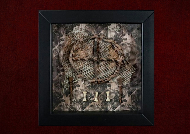 Detailed shot of a handcrafted willow branch sun wheel harvested during a summer solstice on a snake skin backdrop inside a pagan curio frame.