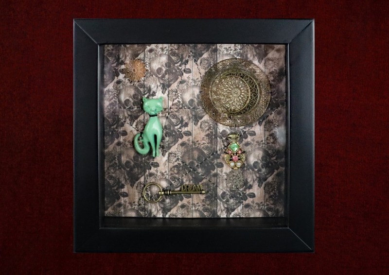 Detailed shot of a vintage Bakelite cat spirit guide curio and a repurposed vintage feline earring inside a traditional pagan shadow box.