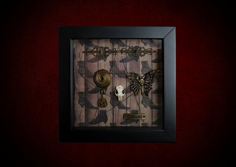 Repurposed black shadow box frame featuring an authentic rat skull, butterfly skull-key, and a "BELIEVE" plaque on a witch's boots backdrop.