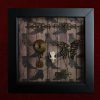 Detailed view of a delicate rat skull specimen resting on a machine-sewn pentagram inside a pagan curio display.