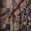 Close-up view of a wire-wrapped amethyst tree of life sculpture anchoring the right side of an occult curiosity display.