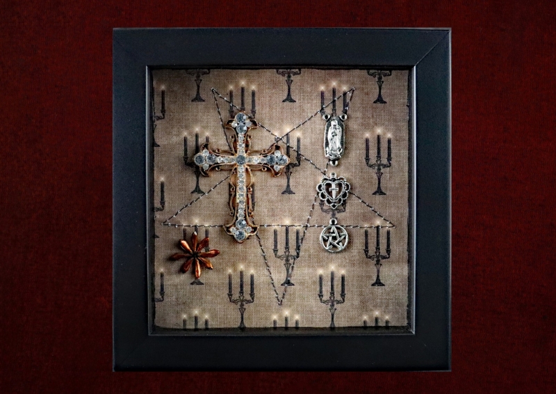 Detailed shot of the Virgin Mary motif, Victorian filigree heart pendant, and pentacle charm arranged in a linear formation.
