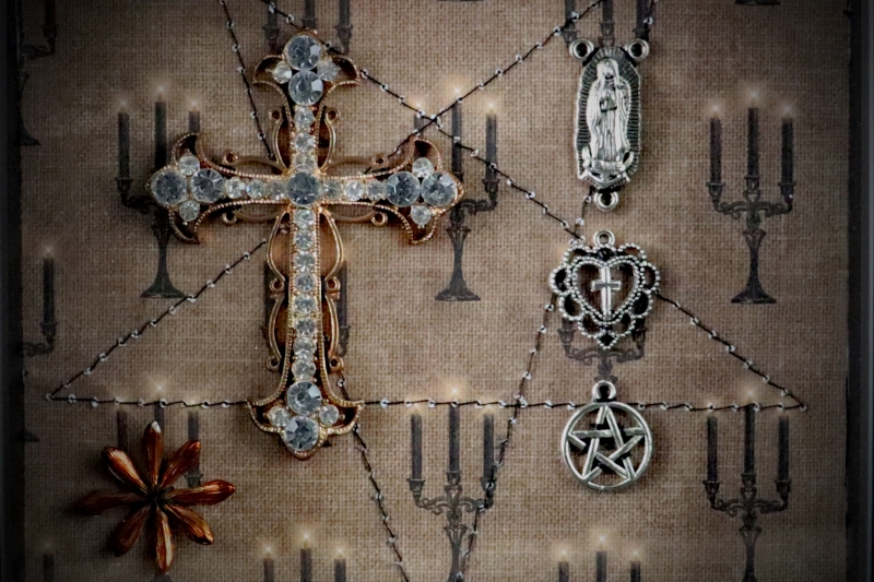 Detailed view of the 7cm sparkling diamante-loaded cross centrepiece inside a traditional gothic curiosity display frame.