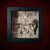 Repurposed black shadow box frame featuring a central dragonfly, flying bird charm, and a vintage mauve diamante brooch on a candelabra backdrop.