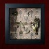 Detailed view of the central dragonfly charm flanked by smaller charms in flight inside a traditional gothic curiosity display frame.