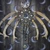 Macro photograph focusing on the contrasting textures of the smooth white hare bones, sparkling vintage diamantes, and the machine-sewn thread pentagram.