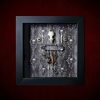 Repurposed black shadow box frame featuring a symmetrical layout with a real rat skull above an ornate metal chatelaine hanging a filigree heart, a gemstone pendant, a preserved rat paw, and an ornate key on a skull and ivy backdrop.