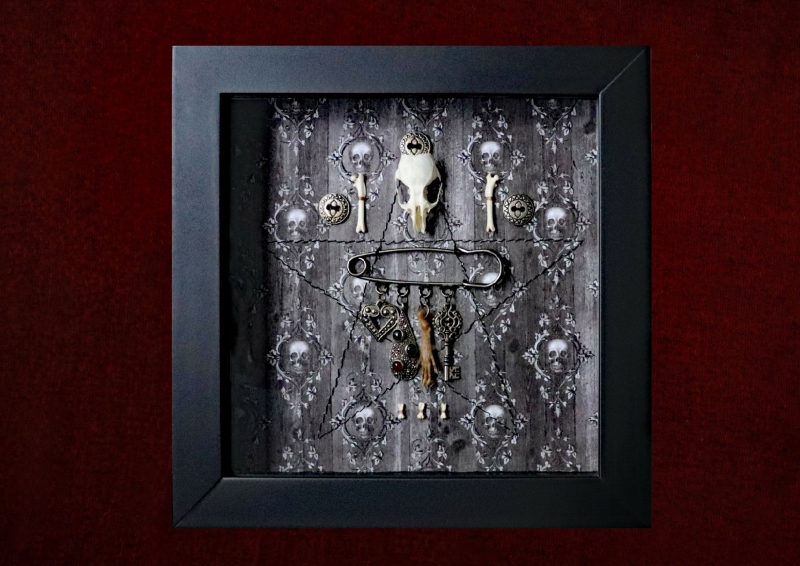 Close-up shot focusing on the top of the display, highlighting the delicate genuine rat skull and matching bone elements flanked by two identical metal filigree buttons over a machine-sewn pentagram.