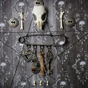 Detailed close-up of the chatelaine assembly showing the intricate textures of the silver marcasite pendant, the real preserved rat paw, the filigree heart, and the vintage-style metal key.